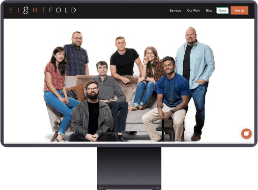 A photo of the Eightfold team posing ariund a couch